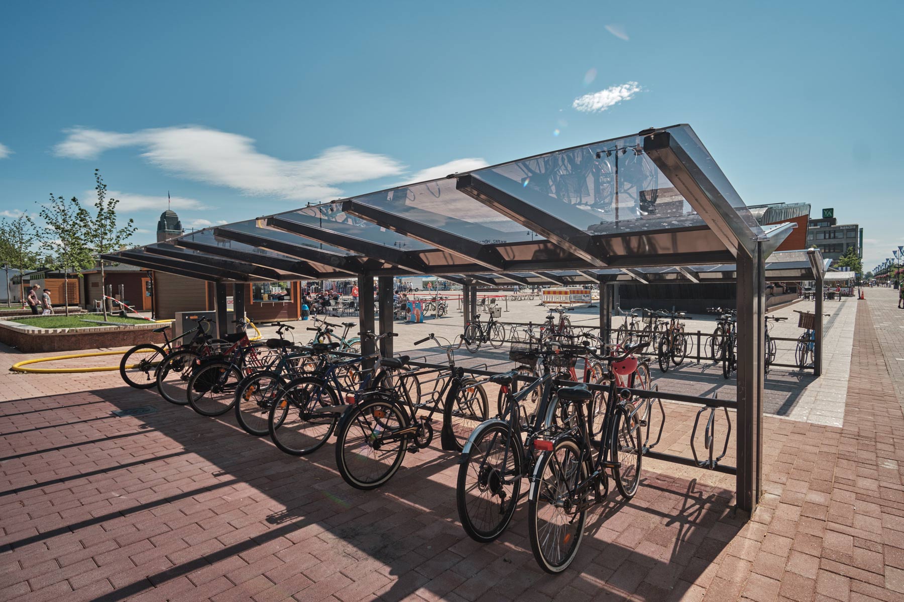 Kartiomaiset kattotuolit, lasimainen ja läpinäkyvä katos LIGHT pyöräkatoksella, Joensuun tori kesällä 2019